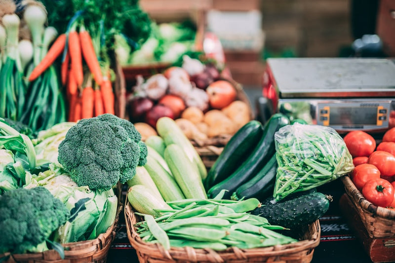 Assortment of fruits and vegetables displayed on a wooden grocery store counter