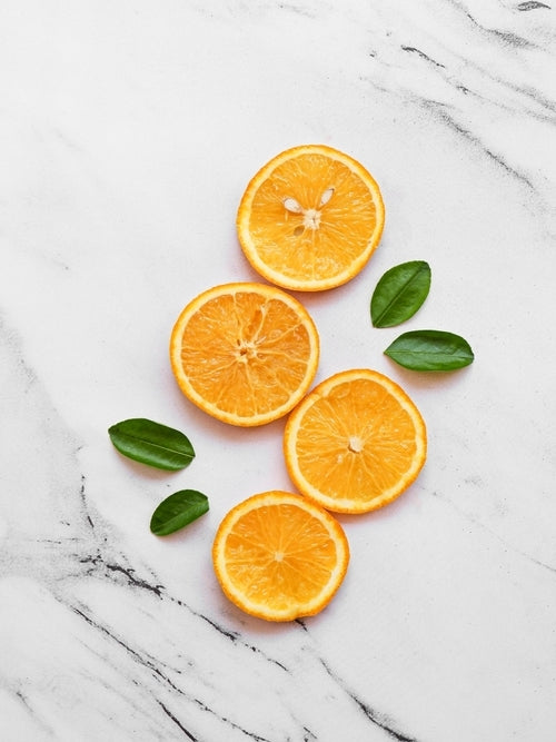 Orange slices displayed on a white marble countertop